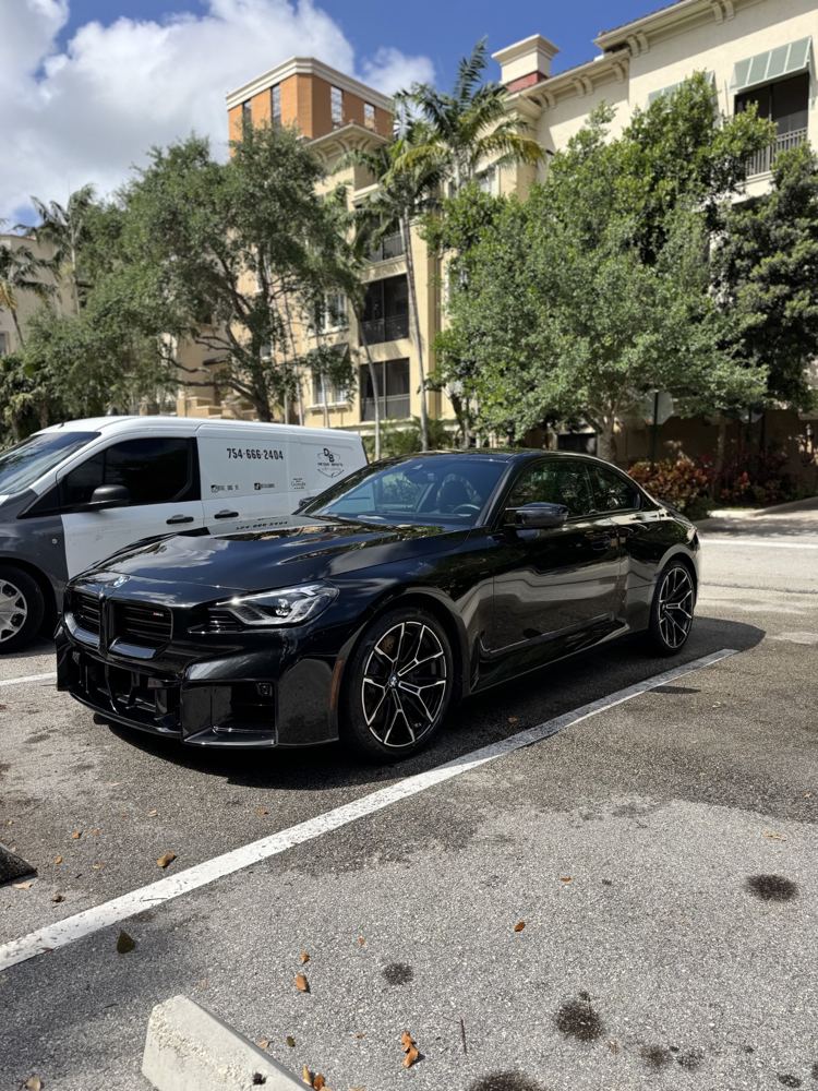 Black BMW M2 next to the Detail Bros van